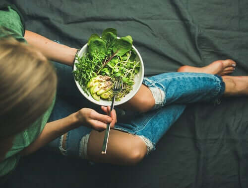 Mulher comendo salada