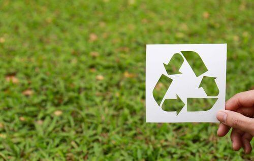 Logotipo de reciclagem em fundo de grama
