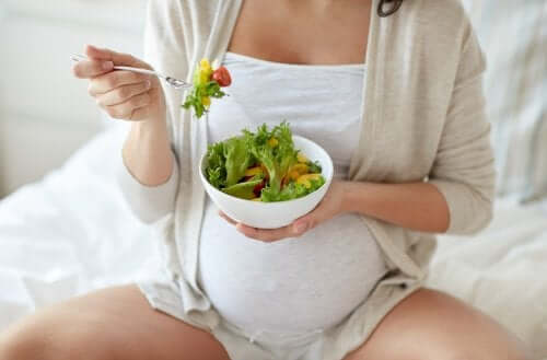 Mulher grávida comendo salada