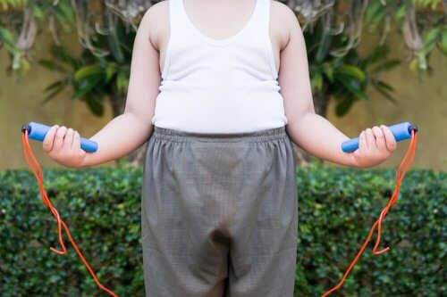 Criança obesa pulando corda