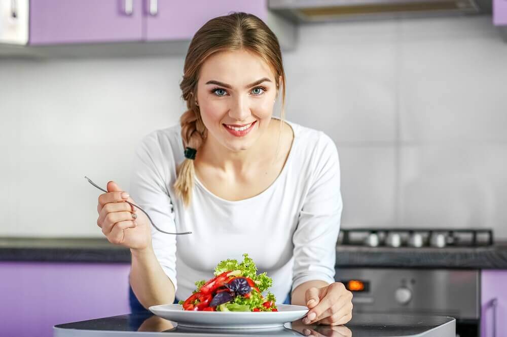 Mulher comendo salada