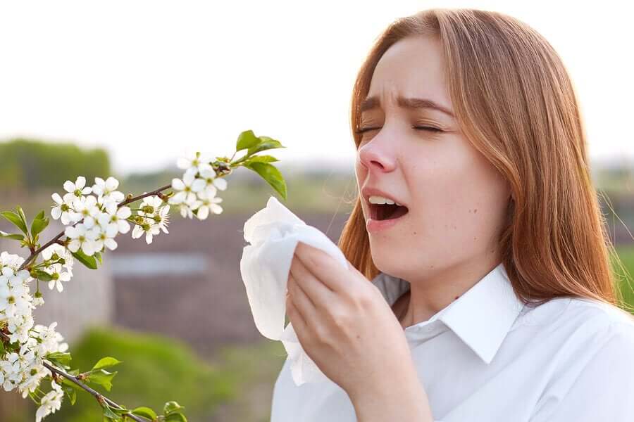 Mulher com alergia espirrando