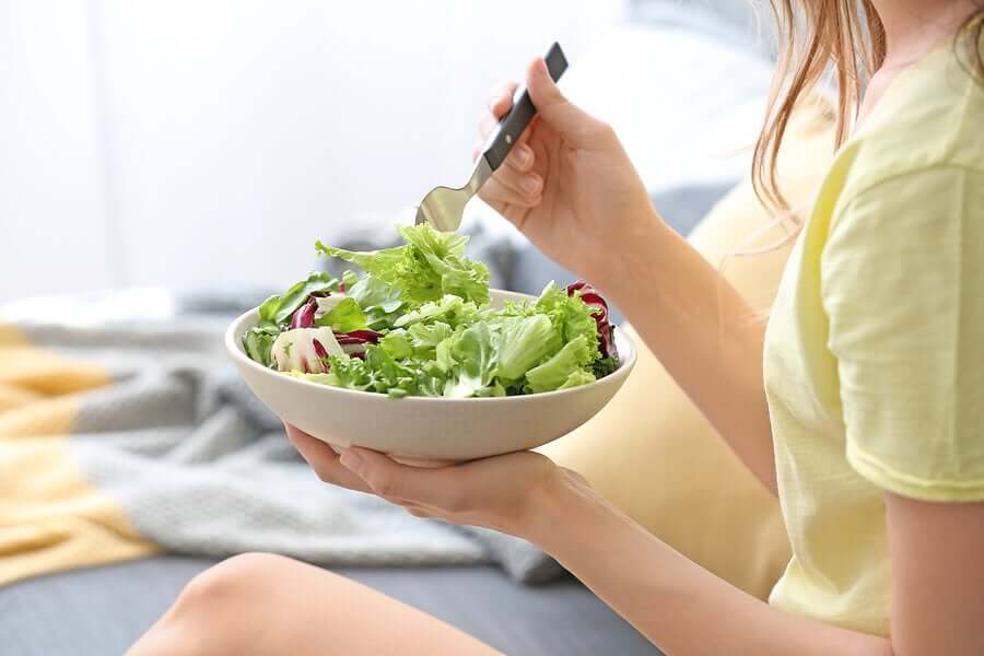 Mulher comendo salada
