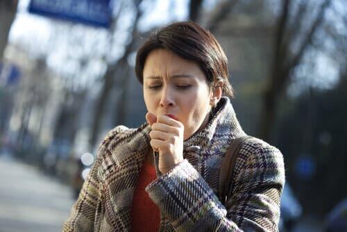 Mulher tossindo na rua