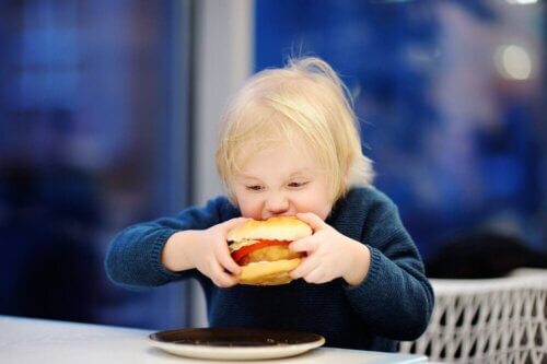 Criança comendo hambúrguer