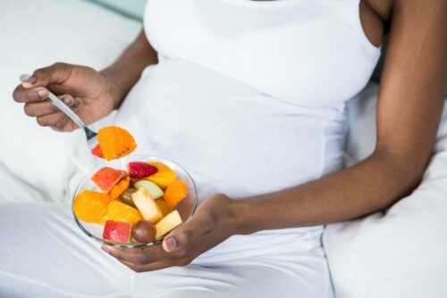 Mulher grávida comendo salada de frutas
