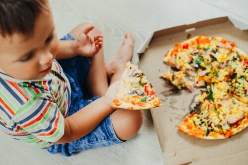 Menino comendo pizza