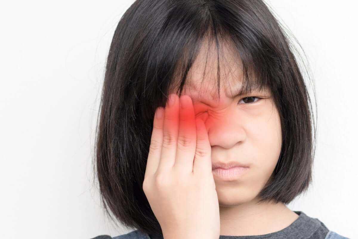Menina com dor nos olhos