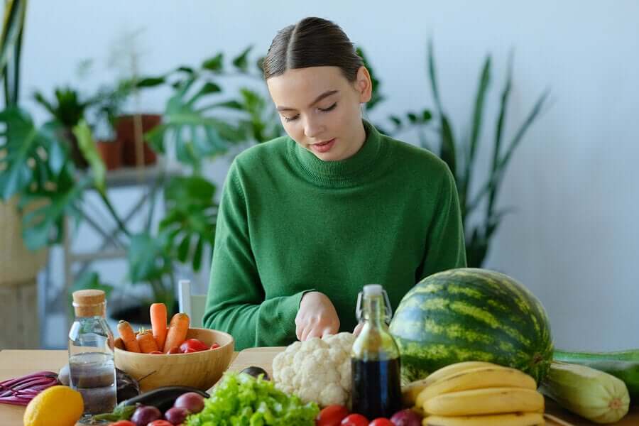 Mulher cortando frutas e verduras