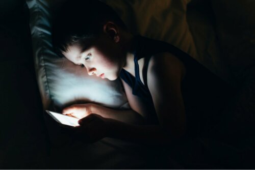 Menino usando tablet antes de dormir