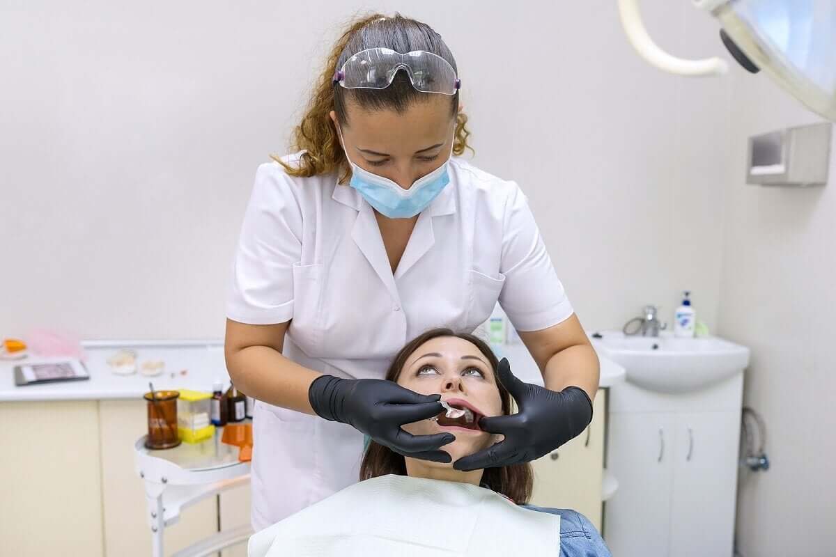 Mulher colocando prótese nos dentes