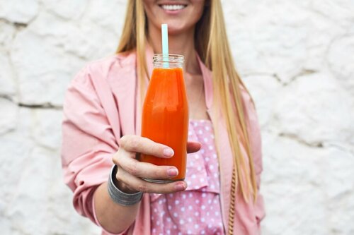 Mulher tomando suco de cenoura
