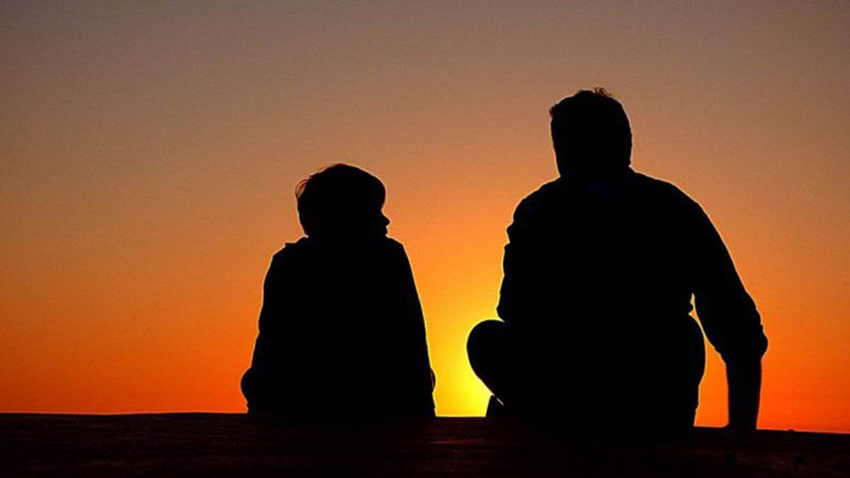 Pai e filho diante do pôr do sol