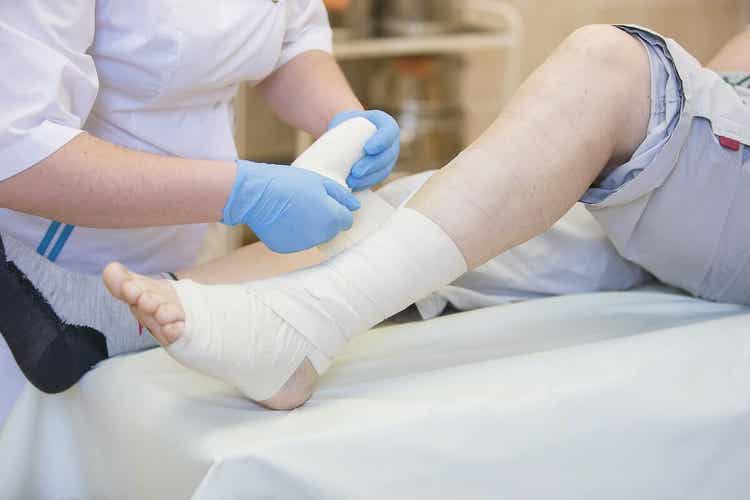 Médico enfaixando paciente